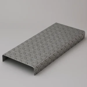 Peldaño metálico de chapa estampada galvanizada con superficie antideslizante y acabado industrial.