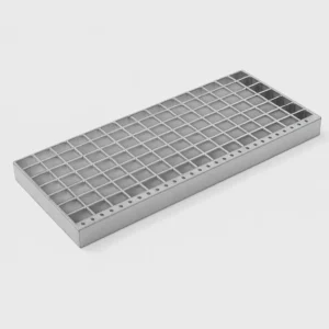 Peldaño tramex de acero galvanizado con superficie antideslizante y perforaciones frontales, sobre fondo gris liso con iluminación de estudio profesional.